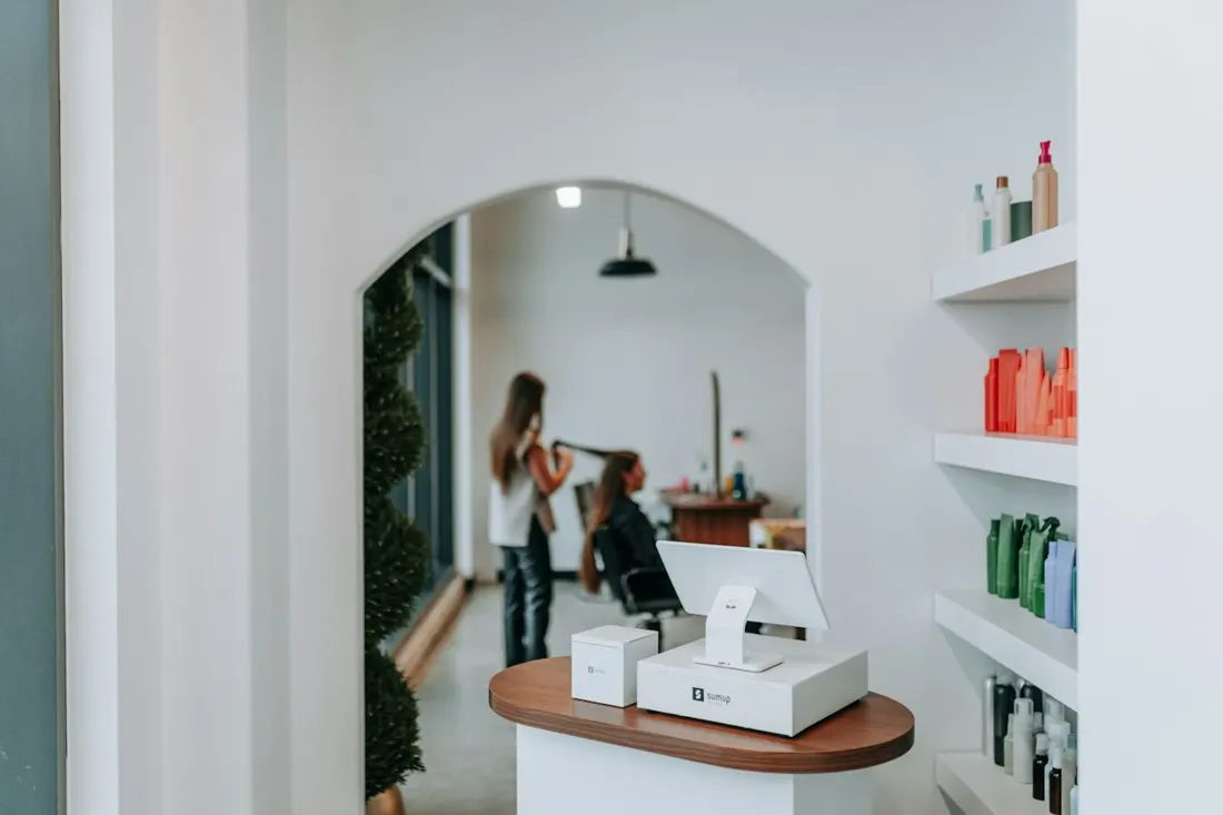 Entrée du salon, comptoir d’accueil et étagères de produits