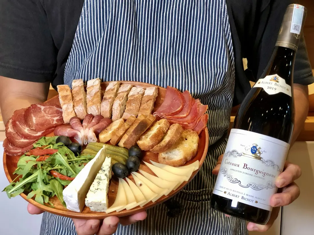 Assiette de charcuterie et bouteille de vin présentées en salle